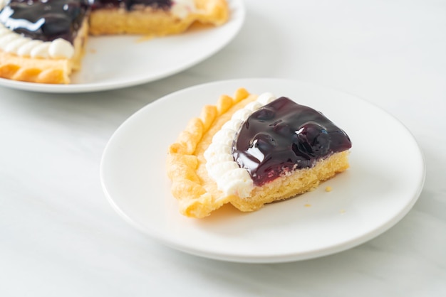 Deliciosa tarta de queso con arándanos en la placa blanca.