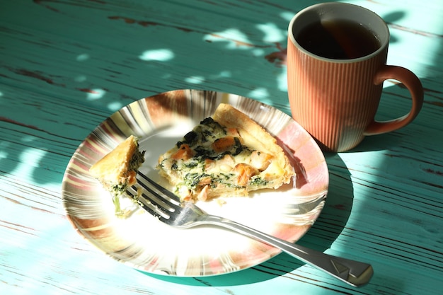Deliciosa tarte de quiche com peixe salmão e nozes de pinheiro preenchendo pequeno-almoço com uma chávena de café