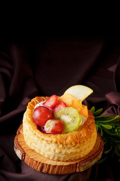 Deliciosa torta de massa folhada com bagas vermelhas feitas em casa, colocadas em uma comida de cozinha gourmet de madeira