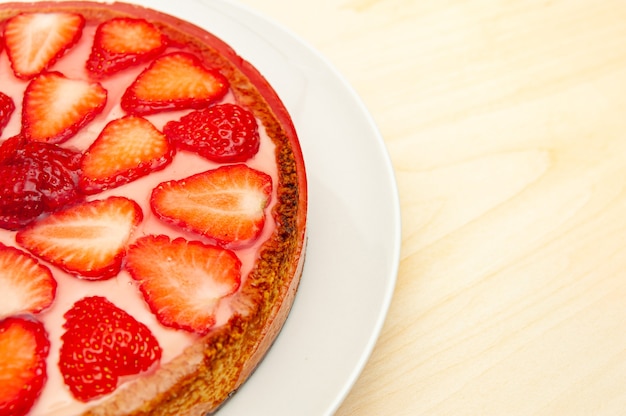 Foto deliciosa torta de morango caseira isolada em fundo de madeira