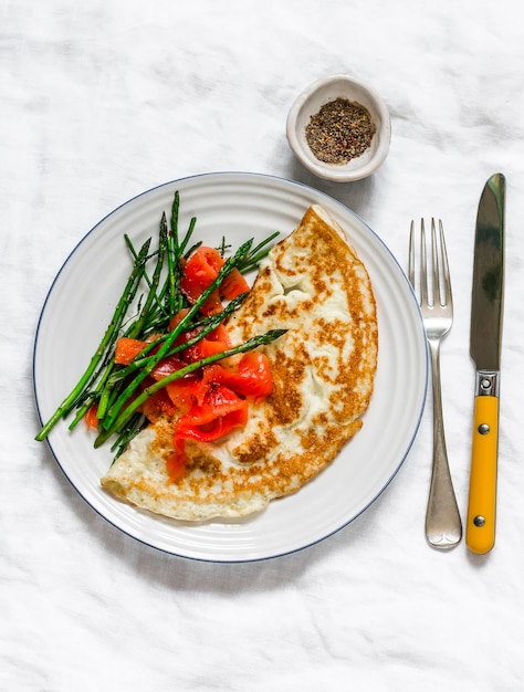 Deliciosa tortilla de brunch de desayuno con espárragos y salmón ahumado en una vista superior de fondo claro