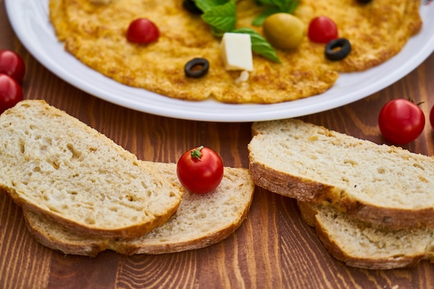 Deliciosa tortilla con pan y tomate