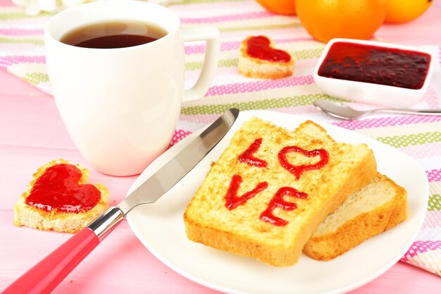 Deliciosa tostada con mermelada y taza de té en primer plano de la mesa