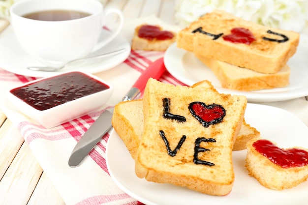 Deliciosa tostada con mermelada y taza de té en primer plano de la mesa