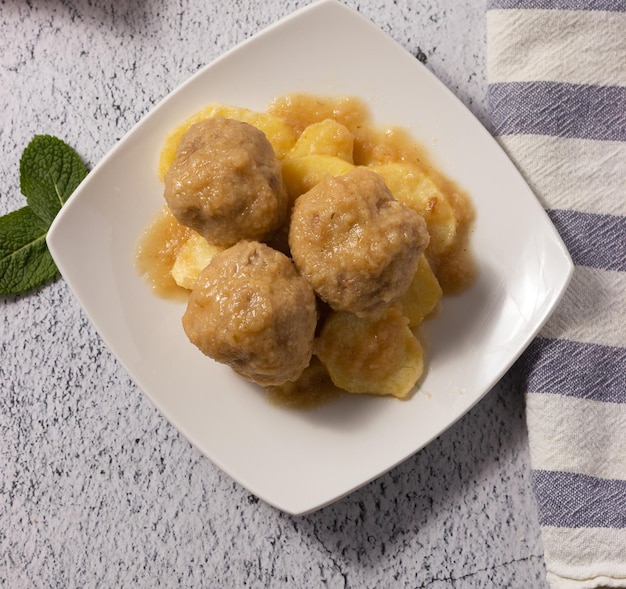 Deliciosas albóndigas caseras con patatas y salsa tradicional