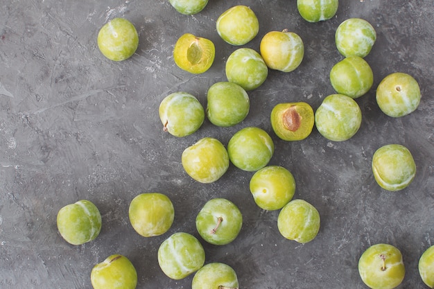 Deliciosas ameixas verdes maduras Greengages Fundo de concreto texturizado preto