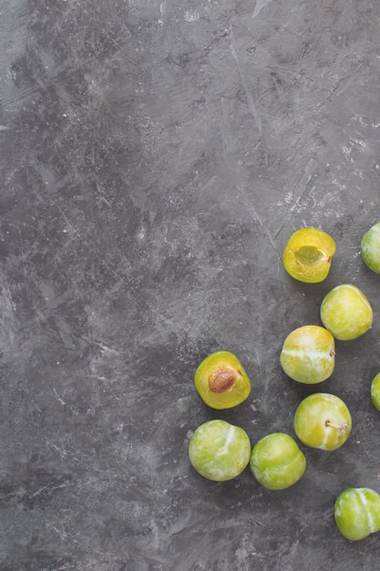 Deliciosas ameixas verdes maduras Greengages Fundo de concreto texturizado preto