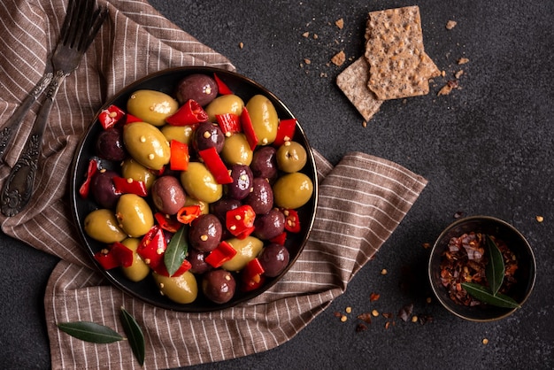 Deliciosas azeitonas verdes e vermelhas com pimenta vermelha e folhas de oliveira saudável aperitivo picante