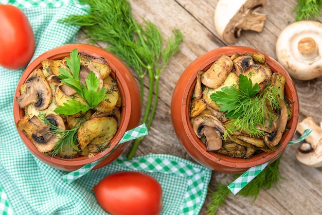 Deliciosas batatas assadas com cogumelos e carne no forno. em uma mesa de madeira. Vista do topo.