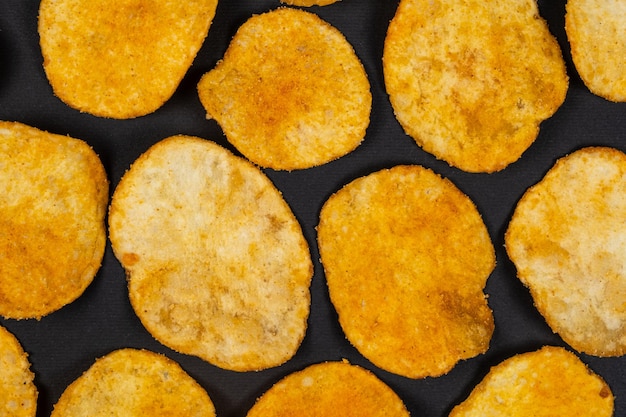 Deliciosas batatas fritas crocantes com especiarias em um fundo preto