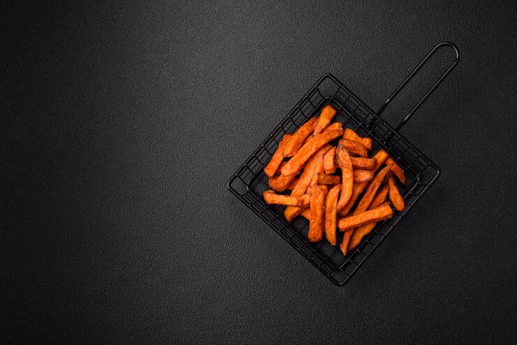 Foto deliciosas batatas fritas crocantes com especiarias salgadas e ervas em um fundo de concreto escuro