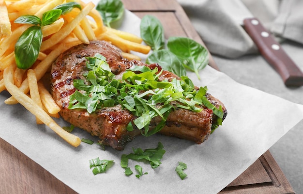 Deliciosas batatas fritas de bife grelhado em papel encerado