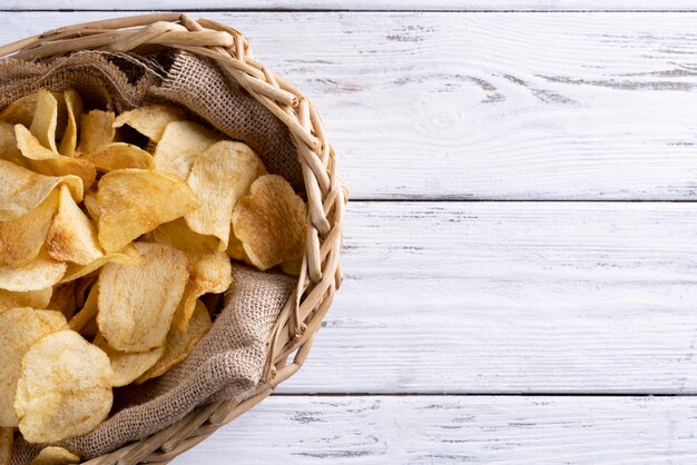 Deliciosas batatas fritas douradas sobre um fundo branco de madeira.