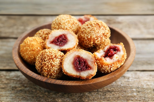 Deliciosas bolas de gergelim com pasta de feijão vermelho na mesa de madeira fechada