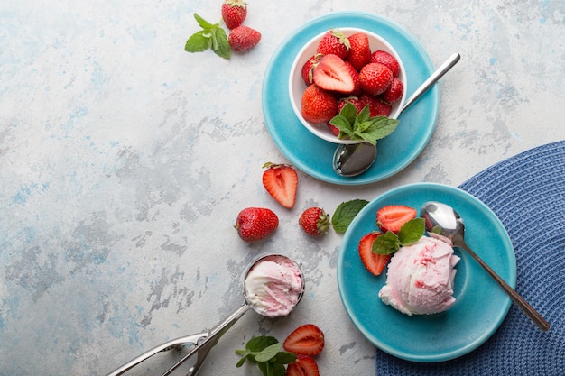 deliciosas bolas de helado de fresa bolas en plato azul con menta.