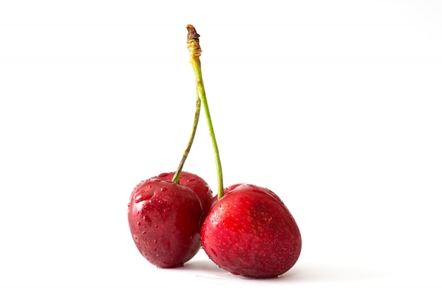 Deliciosas cerezas en pared blanca