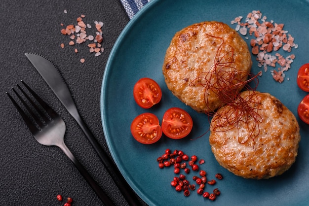 Deliciosas chuletas de pescado picado fresco frito con especias y hierbas sobre un fondo de hormigón oscuro