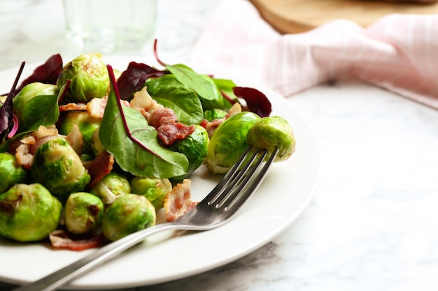 Deliciosas coles de Bruselas con tocino en primer plano de la mesa