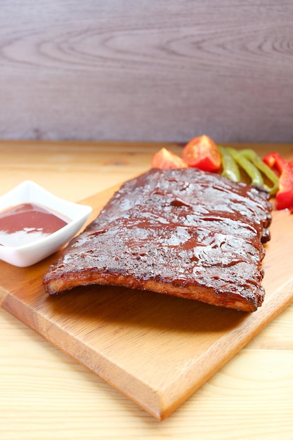 Deliciosas costillas de cerdo a la barbacoa con parrilla en una tabla para cortar