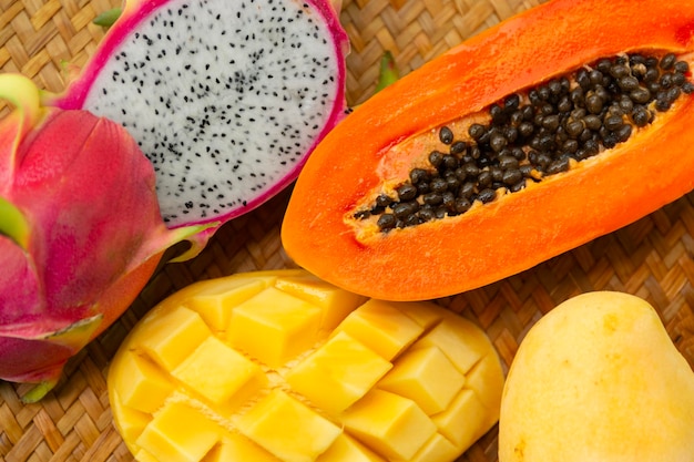 Deliciosas frutas tropicales exóticas vista de arriba en el fondo de una alfombra de mimbre