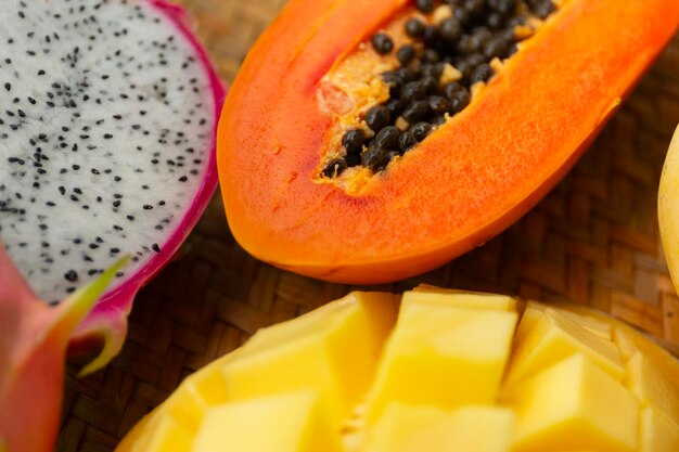 Foto deliciosas frutas tropicales exóticas vista de arriba en el fondo de una alfombra de mimbre