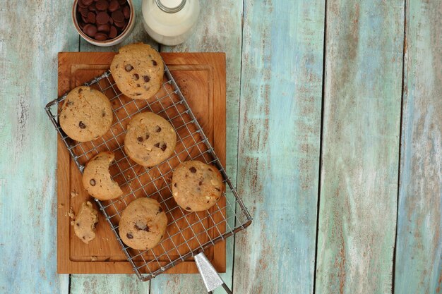 Deliciosas galletas de chispas de chocolate con fondo verde de Bottleson de leche desde la vista superior