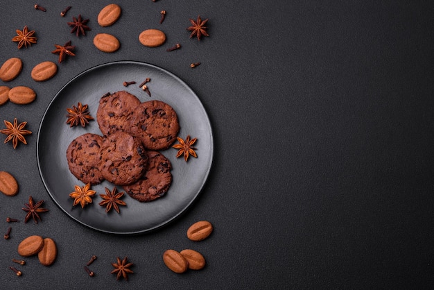 Deliciosas galletas de chocolate con nueces en un plato de cerámica negra sobre un fondo de hormigón oscuro