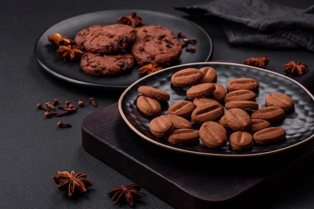 Deliciosas galletas de chocolate con nueces en un plato de cerámica negra sobre un fondo de hormigón oscuro