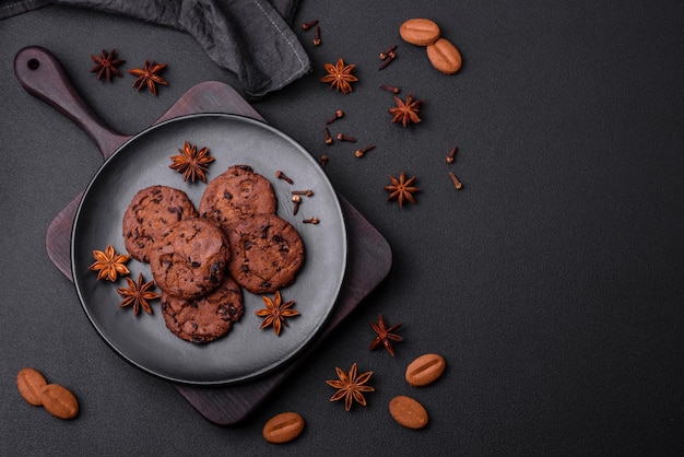 Deliciosas galletas de chocolate con nueces en un plato de cerámica negra sobre un fondo de hormigón oscuro