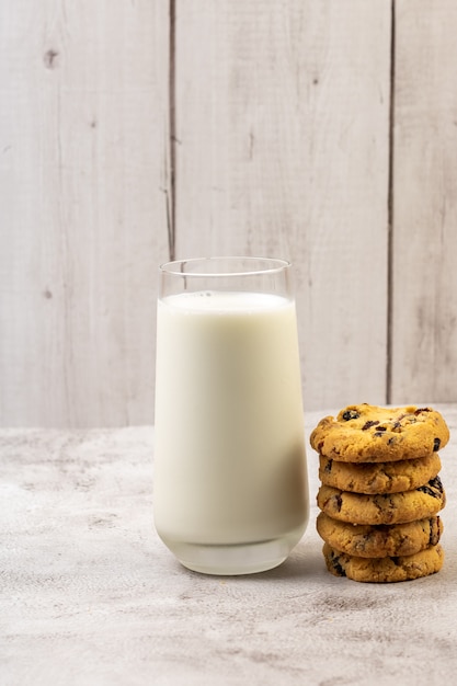 Deliciosas galletas con cramberries y vaso de leche en la mesa