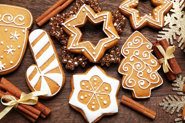 Deliciosas galletas de jengibre y decoración navideña en la mesa de madera, cerrar