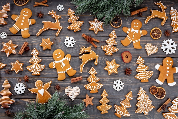 Deliciosas galletas de jengibre y decoración navideña sobre fondo de madera.