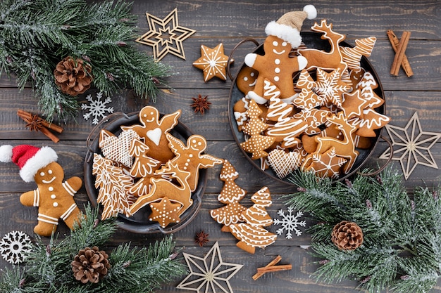 Deliciosas galletas de jengibre y decoración navideña sobre fondo de madera.