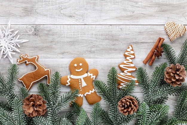 Deliciosas galletas de jengibre y decoración navideña sobre fondo de madera.