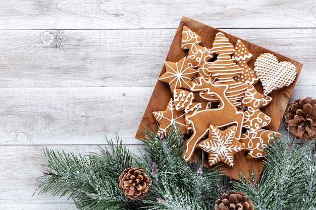 Deliciosas galletas de jengibre y decoración navideña sobre fondo de madera.