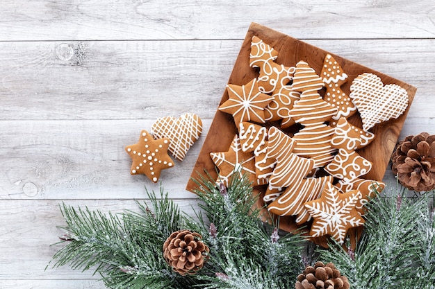 Deliciosas galletas de jengibre y decoración navideña sobre fondo de madera.