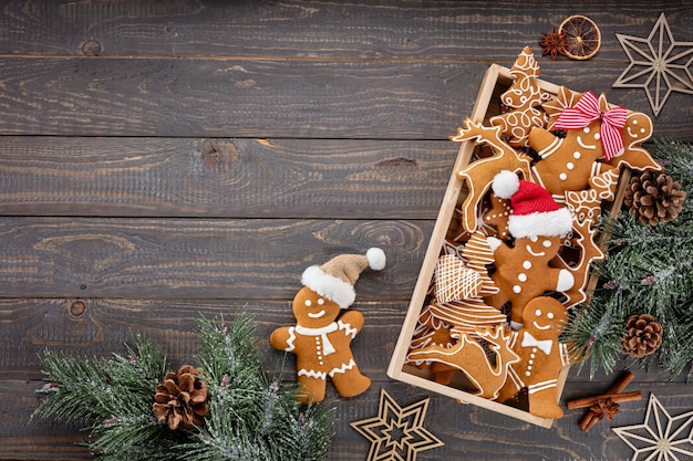 Deliciosas galletas de jengibre y decoración navideña sobre fondo de madera.