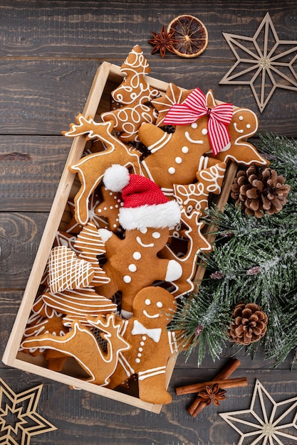 Deliciosas galletas de jengibre y decoración navideña sobre fondo de madera.