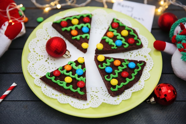 Deliciosas galletas de Navidad de colores en un plato con decoración festiva