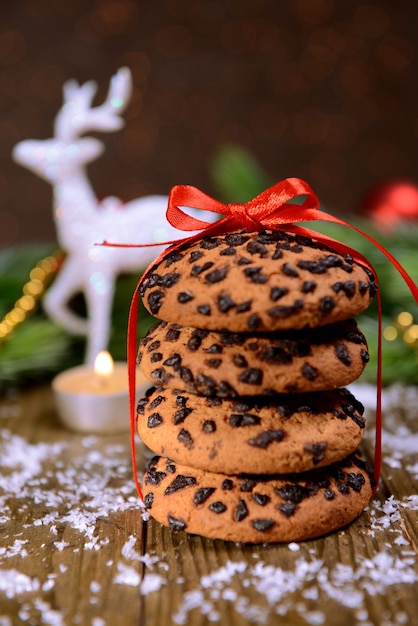 Deliciosas galletas de Navidad en el tarro en la mesa sobre fondo marrón