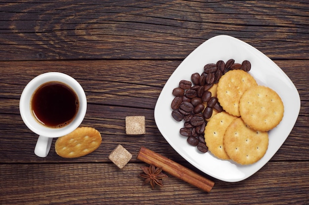 Deliciosas galletas y una taza de café caliente en la mesa de madera, vista superior