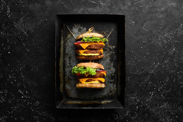 Deliciosas hamburguesas caseras a la parrilla Menú de hamburguesas Vista superior Sobre un fondo de piedra negra