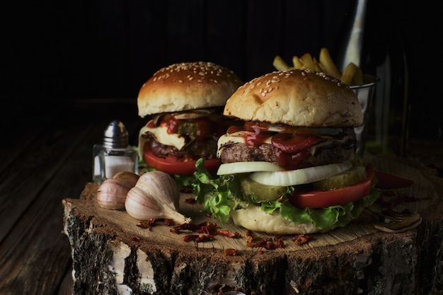 Deliciosas hamburguesas en un estilo rústico sobre fondo de madera oscura.