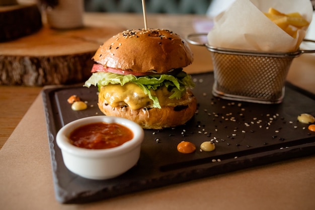 Deliciosas hamburguesas con papas fritas en el fondo borroso.