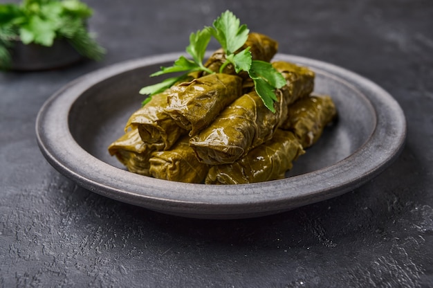 Deliciosas hojas de parra rellenas plato tradicional de oriente medio dolma o sarma con perejil en negro