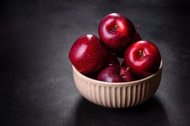 Deliciosas manzanas frescas en rojo sobre un fondo de hormigón oscuro