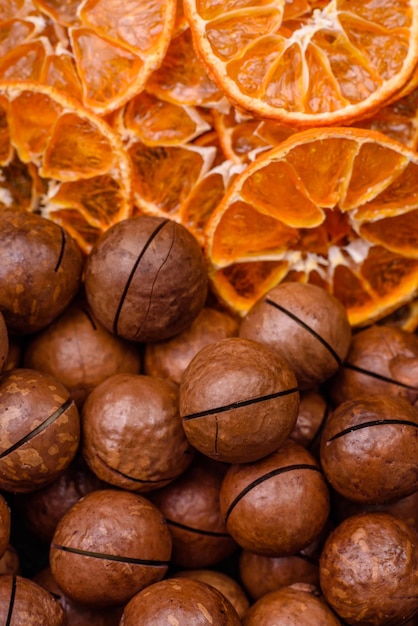 Deliciosas nueces de macadamia tostadas con cáscara sobre un fondo de textura oscura