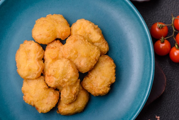 Deliciosas nuggetas de pollo crujientes frescas sobre un fondo de hormigón oscuro
