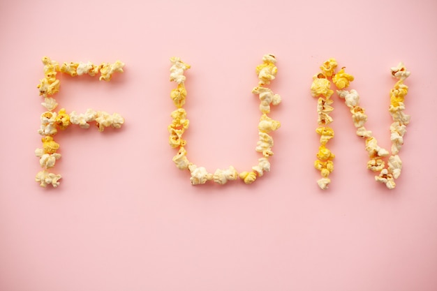 Deliciosas palomitas de maíz sobre fondo rosa