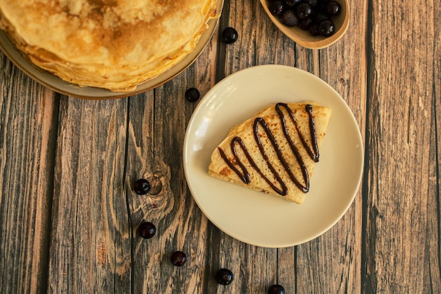 Deliciosas panquecas com calda de chocolate mirtilos frescos em uma mesa de madeira rústica mesa marrom rústica